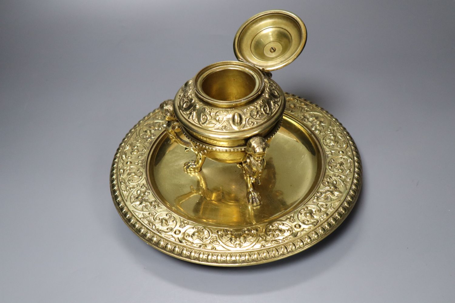 A brass desk stand, with hinged cover, diameter 24cm